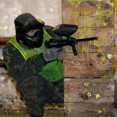 Игрок в пейнтбол с маркером на площадке